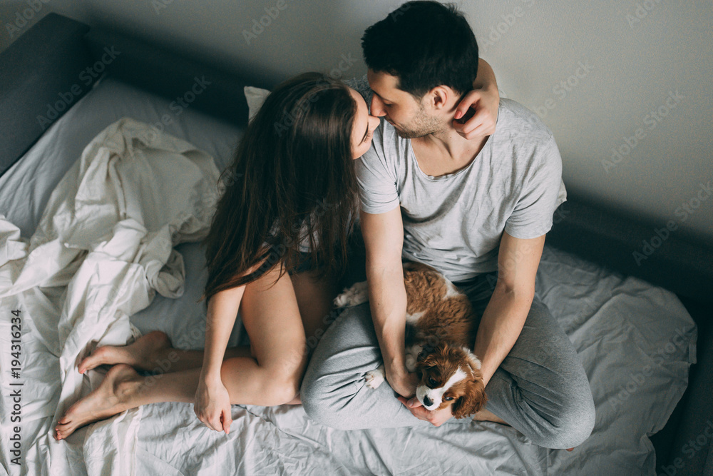 A photo session of a guy and a girl in a cozy home environment. A family member is a little dog. A photo session of a guy and a girl in a cozy home environment. A family member is a little dog.