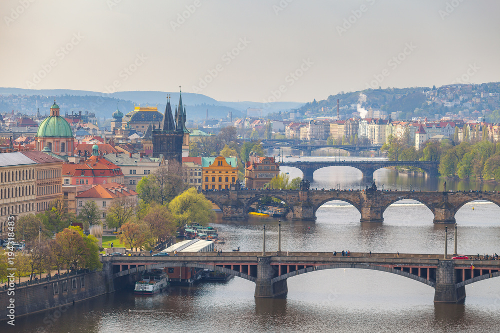 Remarkable view of Prague bridges over Vltava river with historic embankment. Daytime, spring season.