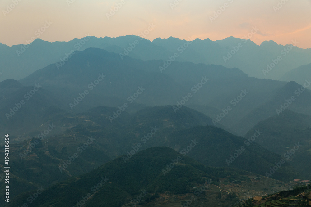 Layers of silhouette mountains with orange sky and sky in the dusk in the dusk in Sa Pa, Vietnam. Layers of silhouette mountains with orange sky and sky in the dusk in the dusk in Sa Pa, Vietnam.