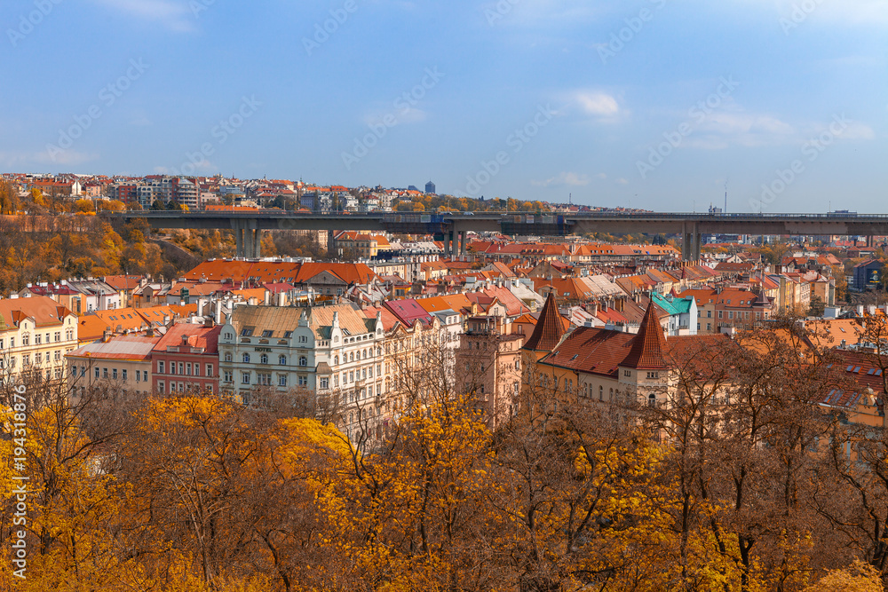Prague living blocks red rooftops with park and trees. Fall season