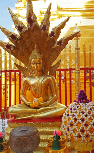 Mucalinda Naga sheltering Gautama Buddha in a small shrine in Doi Suthep Buddhist Temple near Chiang Mai in northern Thailand photo