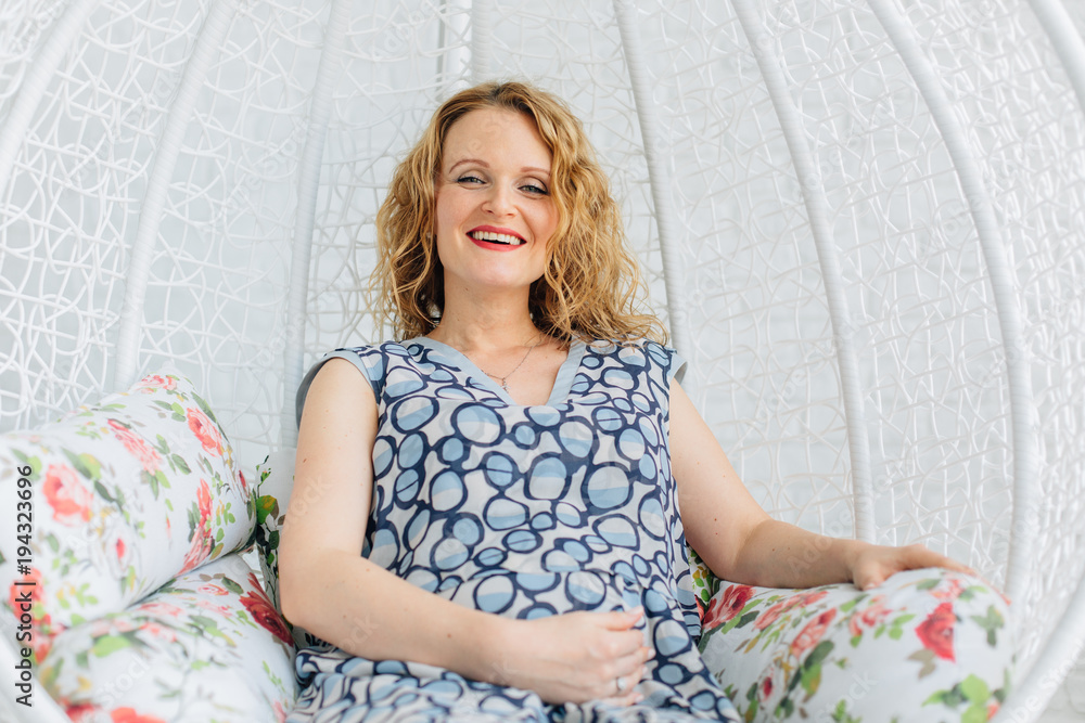 Obraz premium beautiful Pregnant woman sits on swing at home