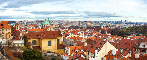 View of Prague over houses with red roofs. Amazing view from above at old historical quarter. Prague, Czech Republic. Prague is famous and popular travel destination city