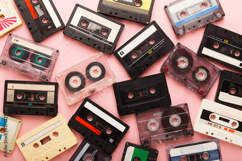 Heap of vintage audio cassettes at pink background