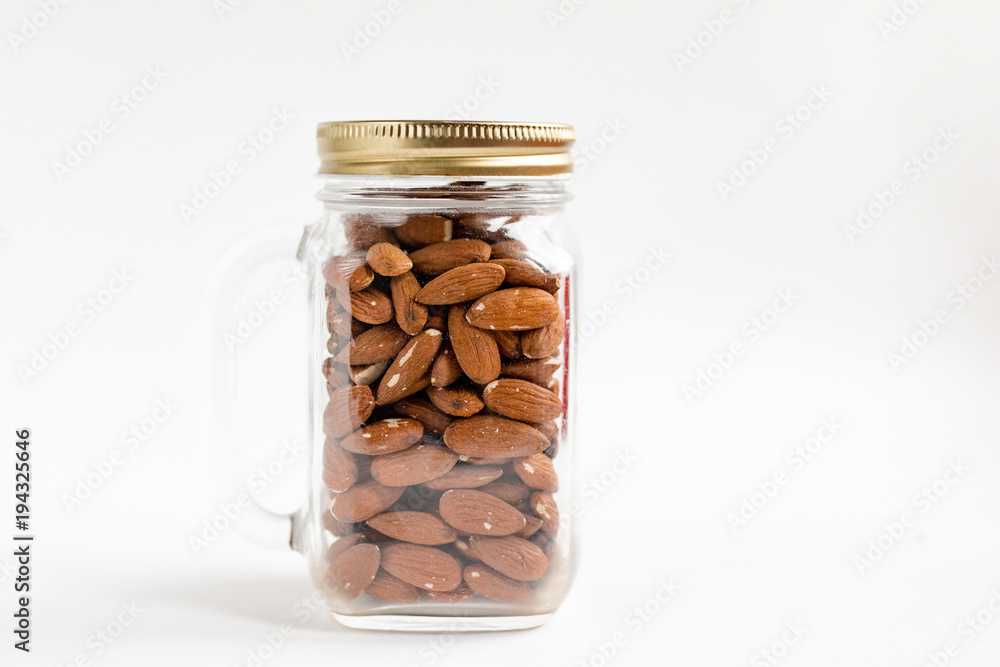 А group of almonds in a jar on white background А group of almonds in a jar on white background