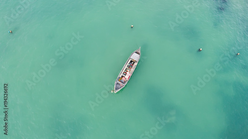 Lonely fishing boat in turquoise ocean, sea. Aerial photo, top view