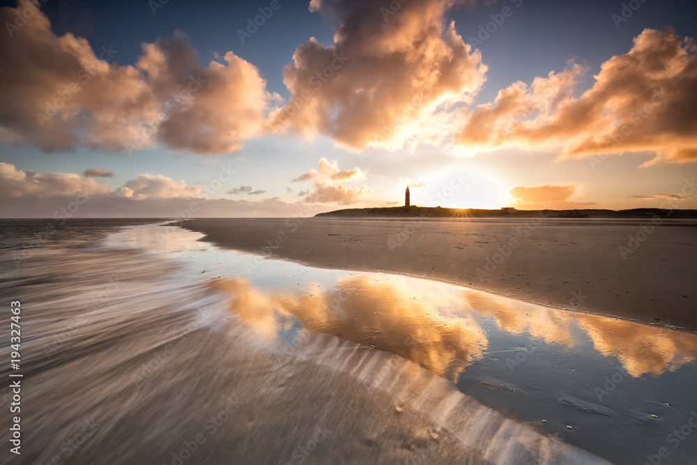Obraz premium dramatic sunrise over North sea coast with lighthouse