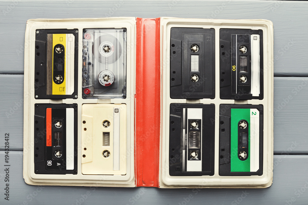 Obraz premium Vintage audio cassettes in white organizer on gray table, top view