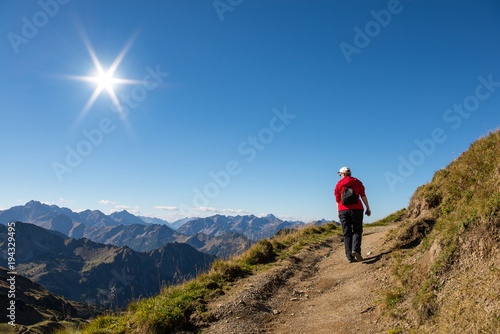 Frau wandert auf Wanderweg im Gebirge