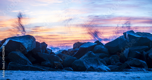 waves crashing on the rocks at sunset
