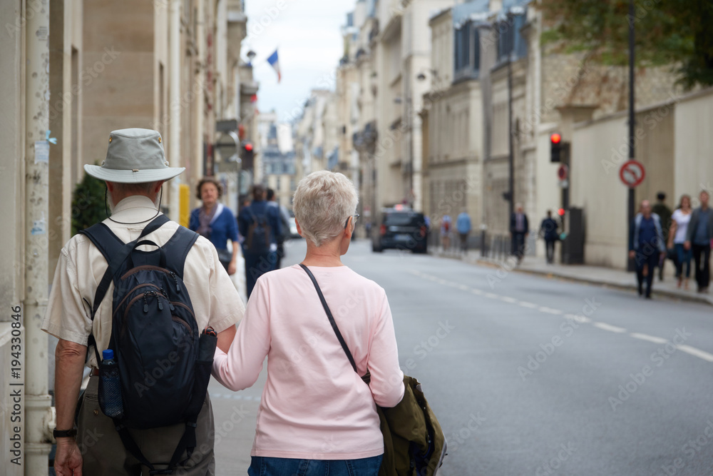 An adult couple of tourists walking through the streets of Paris