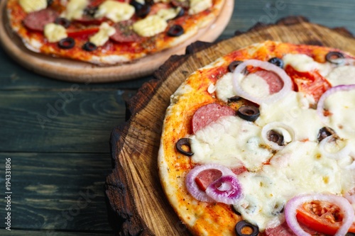 Delicious freshly baked homemade pizzas close up on the wooden board, Italian food, cooking concept