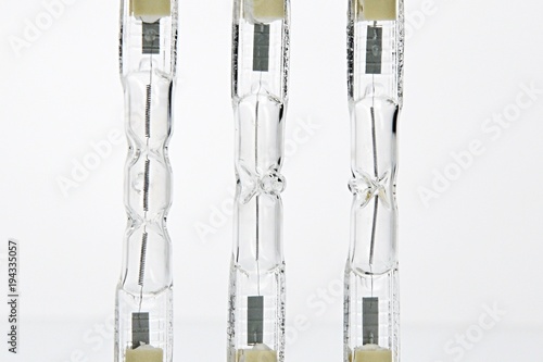 Fotografía Detail of three double ended halogen J type T light bulbs on lit background