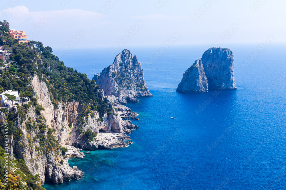 Amazing Faraglioni cliffs panorama with the majestic Tyrrhenian sea in background, Capri island, Campania region, Italy, Europe. Amazing Faraglioni cliffs panorama with the majestic Tyrrhenian sea in background, Capri island, Campania region, Italy, Europe.