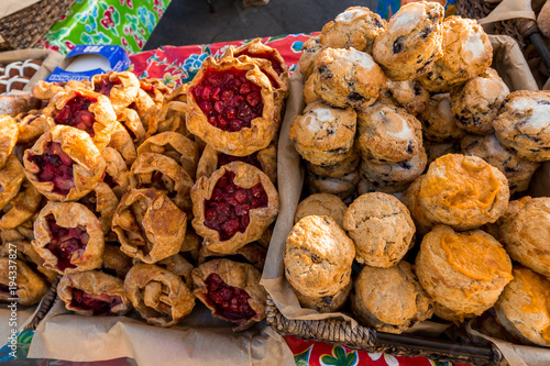 Several different pastries for sale at a farmers market.