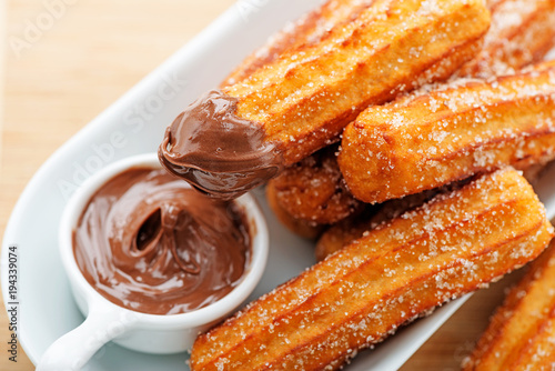 Churros with sugar and chocolate sauce . top view  photo