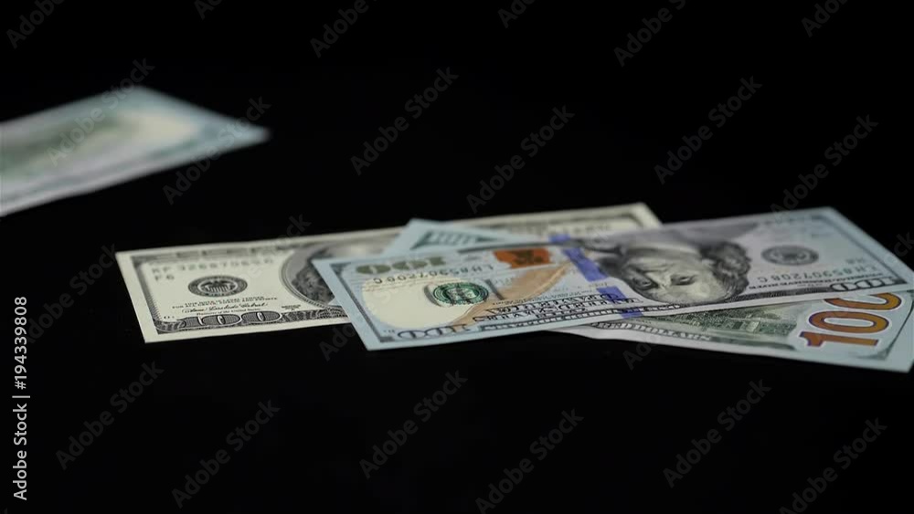 Close up drop dropped view of dollar banknote. Studio shot on black background, super closeup macro of bucks one hundred a lot united states Close up drop dropped view of dollar banknote. Studio shot on black background, super closeup macro of bucks one hundred a lot united states