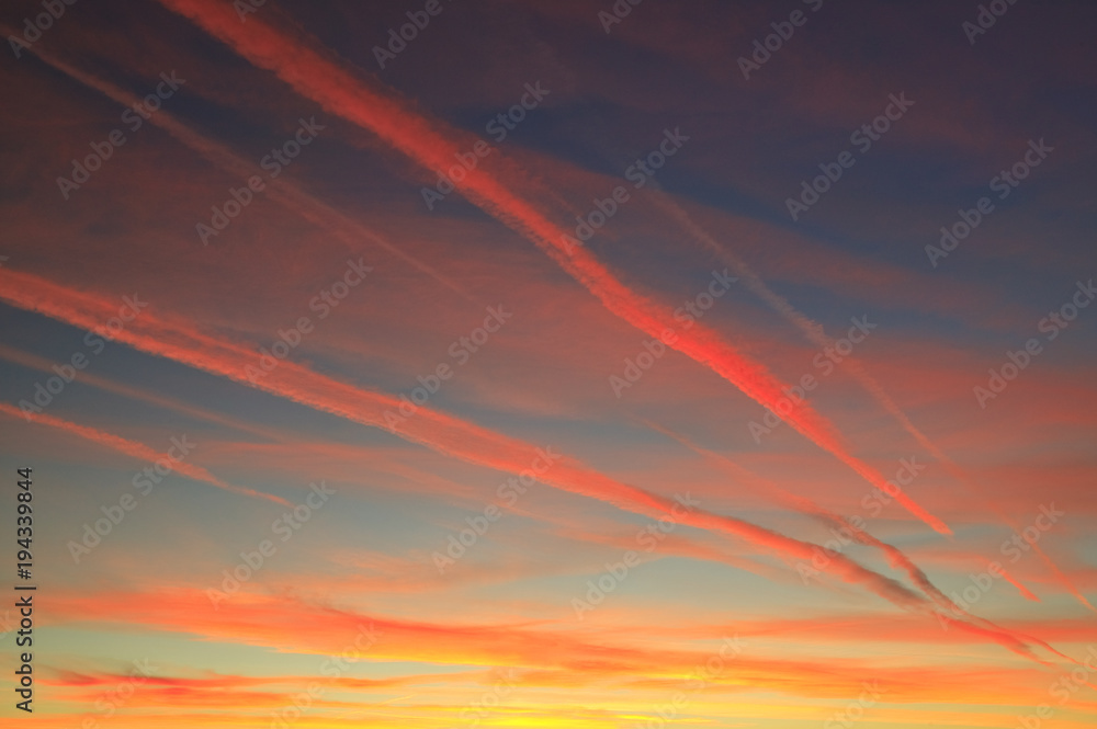 Aircraft vapour trails in a sunset sky
