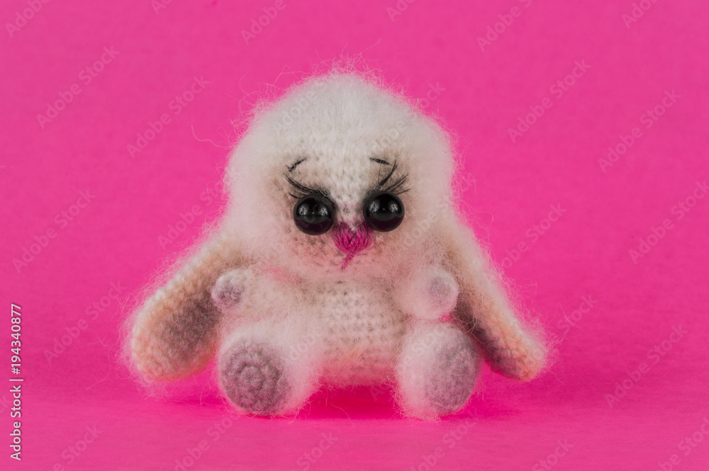 Fototapeta premium knitted toy bunny on a pink background