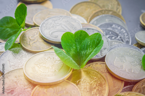 Scattered Russian coins on a gray background with leaves of clover. Good luck, St. Patrick's day. photo