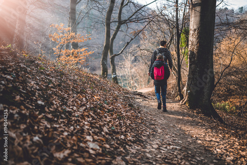 Father and daughter walking on forest trail © kerkezz