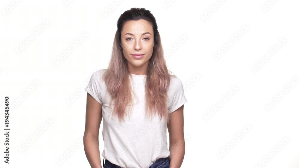 Studio portrait of well-built woman with hands in pockets nodding positively in agreement, over white background closeup. Concept of emotions Studio portrait of well-built woman with hands in pockets nodding positively in agreement, over white background closeup. Concept of emotions