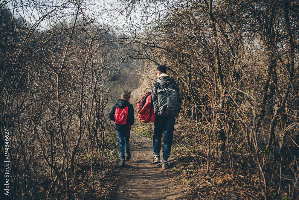 Father and daughter hiking on forest trail Father and daughter hiking on forest trail