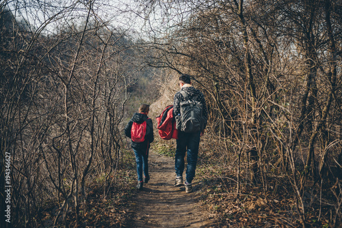 Father and daughter hiking on forest trail