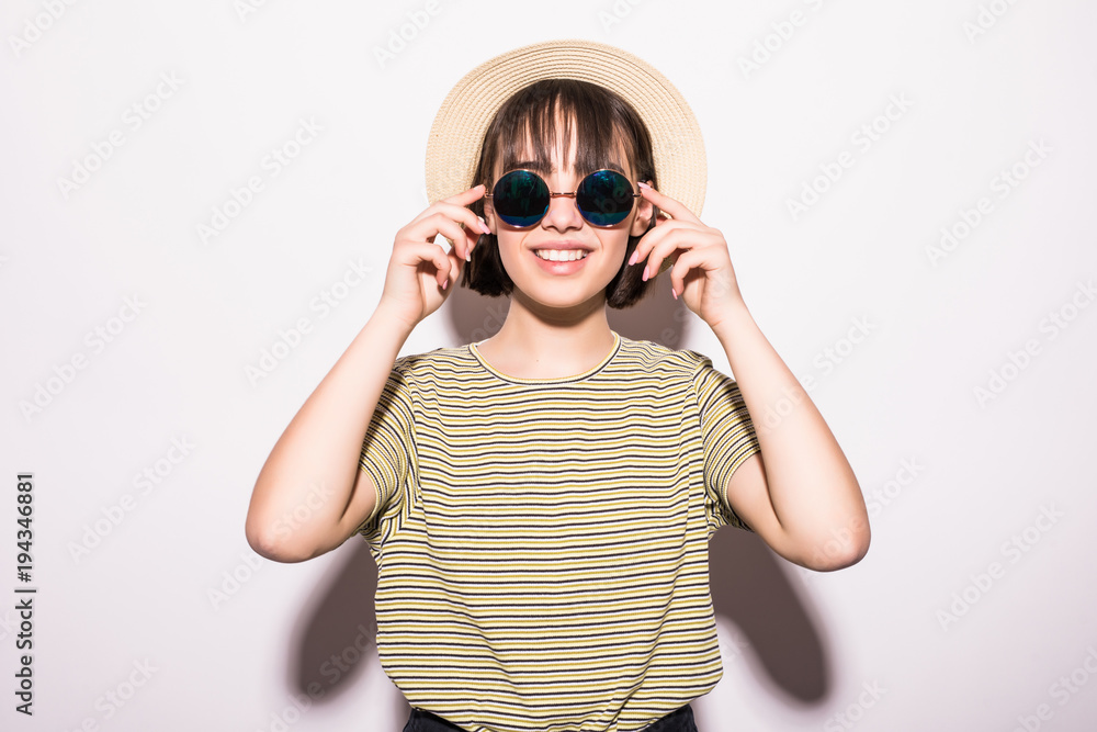 Attractive hipster fashion teen girl in hat, sunglasses in white background Attractive hipster fashion teen girl in hat, sunglasses in white background