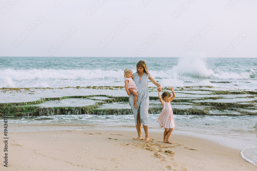 Young mother with two daughters on the beach Young mother with two daughters on the beach
