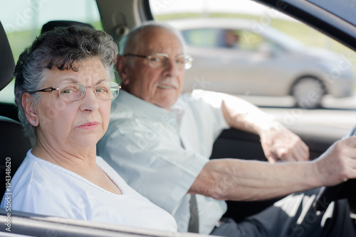happy senior couple sitting inside their car