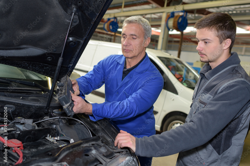 auto mechanic teacher and trainee performing tests at mechanic school auto mechanic teacher and trainee performing tests at mechanic school