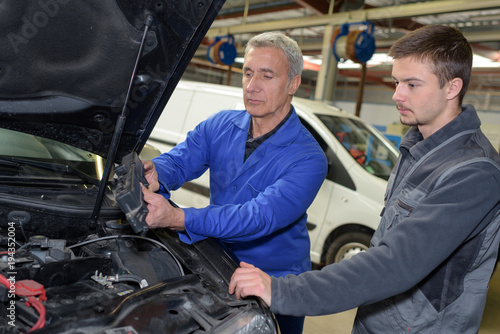auto mechanic teacher and trainee performing tests at mechanic school