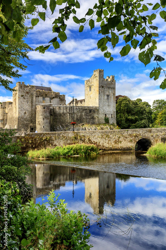 Europe, Ireland, Cahir castle and village at sunset reflecting in Caher river photo