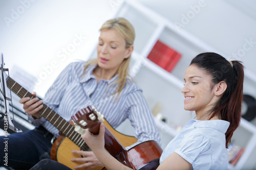 young woman learning to play guitar