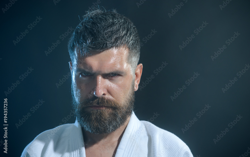 Portrait of a bearded man in a kimono, closeup. Handsome bearded boxer isolated on a green background. Muscular kickboxer or muay thai fighter. Portrait of a bearded man in a kimono, closeup. Handsome bearded boxer isolated on a green background. Muscular kickboxer or muay thai fighter.