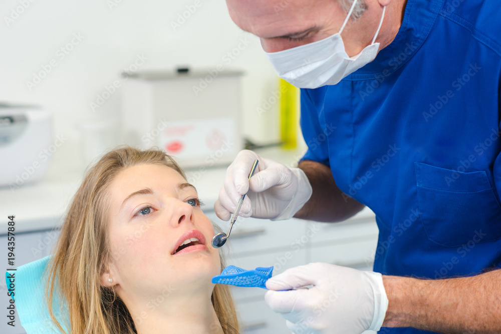 Dentist using mirror to see better Dentist using mirror to see better
