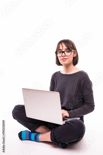 school, education, internet and technology concept - young teen girl sitting on the floor with laptop computer