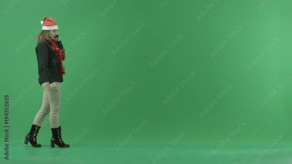 Young female talks over her cellphone while walks, green chroma key background Young female talks over her cellphone while walks, green chroma key background