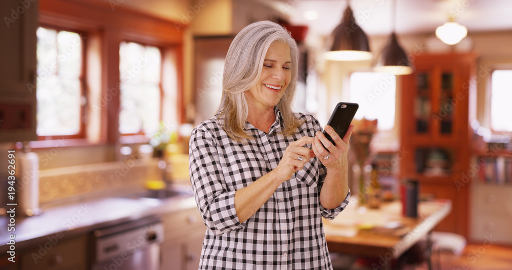 Lovely mid aged woman texting on cell phone device Lovely mid aged woman texting on cell phone device