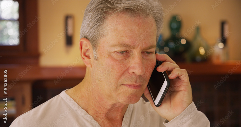 Mature mid aged man talking on a phone Mature mid aged man talking on a phone