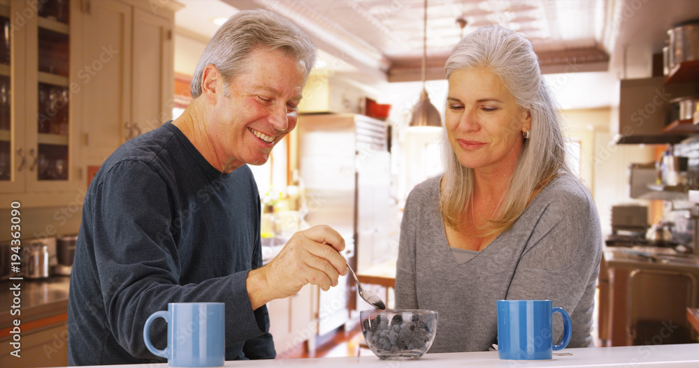 Couple of senior caucasian people sharing bowl of fruit Couple of senior caucasian people sharing bowl of fruit
