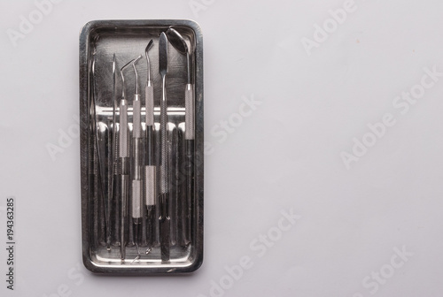 metal tray with medical dental instruments on a white background
