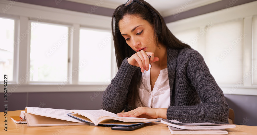 A college student does her homework at her desk in her room. A girl reads and works in her room A college student does her homework at her desk in her room. A girl reads and works in her room