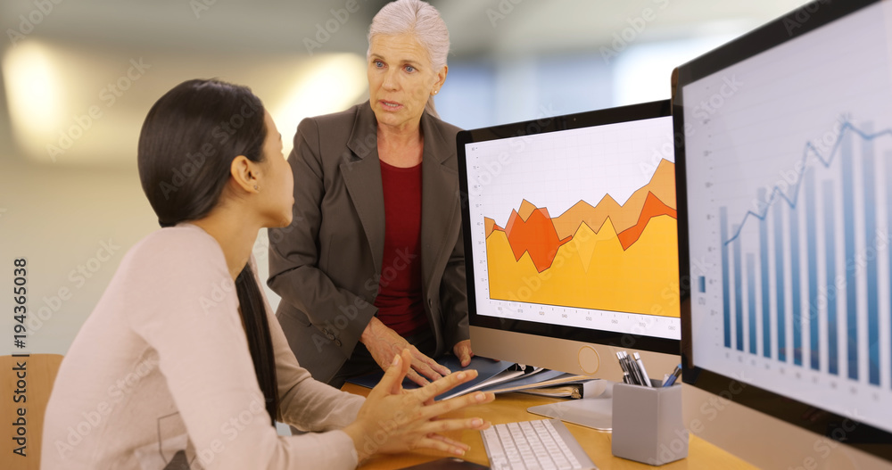 An office executive advises an office worker. Two businesswomen discus work An office executive advises an office worker. Two businesswomen discus work