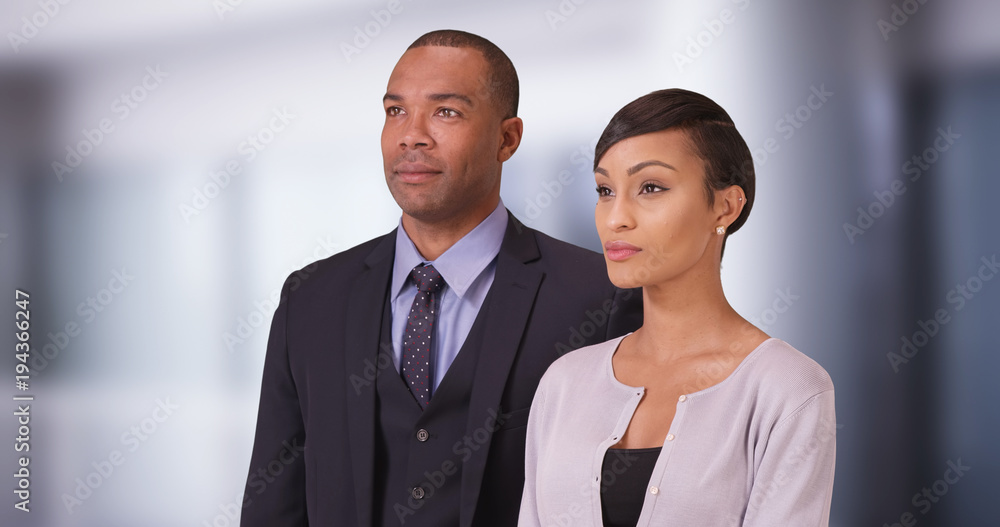 Black business couple posing for a portrait in their office. African American people standing in their business center Black business couple posing for a portrait in their office. African American people standing in their business center