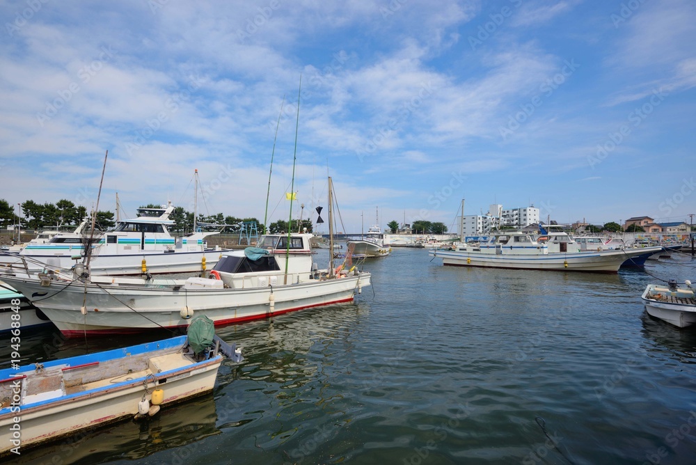 片瀬漁港の停泊する漁船の影と白い雲