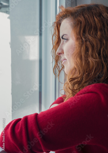 Red-haired girl by the window