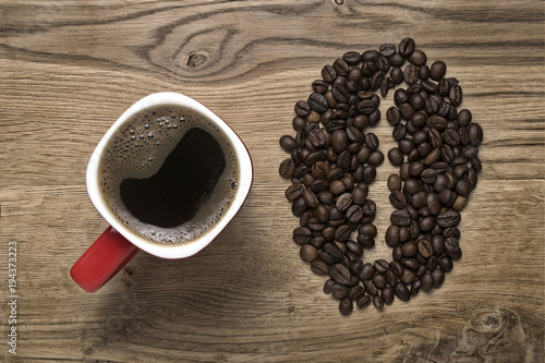 red mug on the background of scattered coffee beans photo