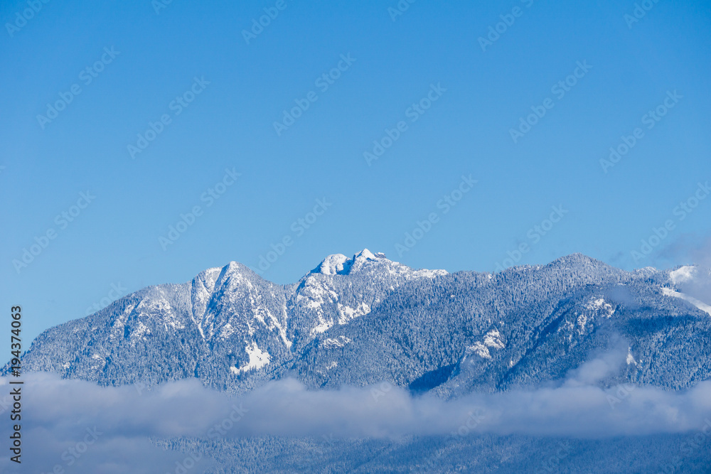 Mountains covered in snow and blue clear sky in nice winter day.